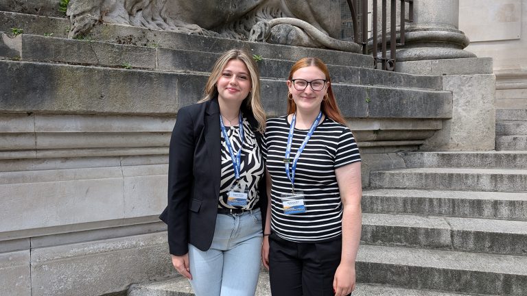 Two young women, Imogen Hambry and Mackenzie Bird, standing on the Guildhall steps